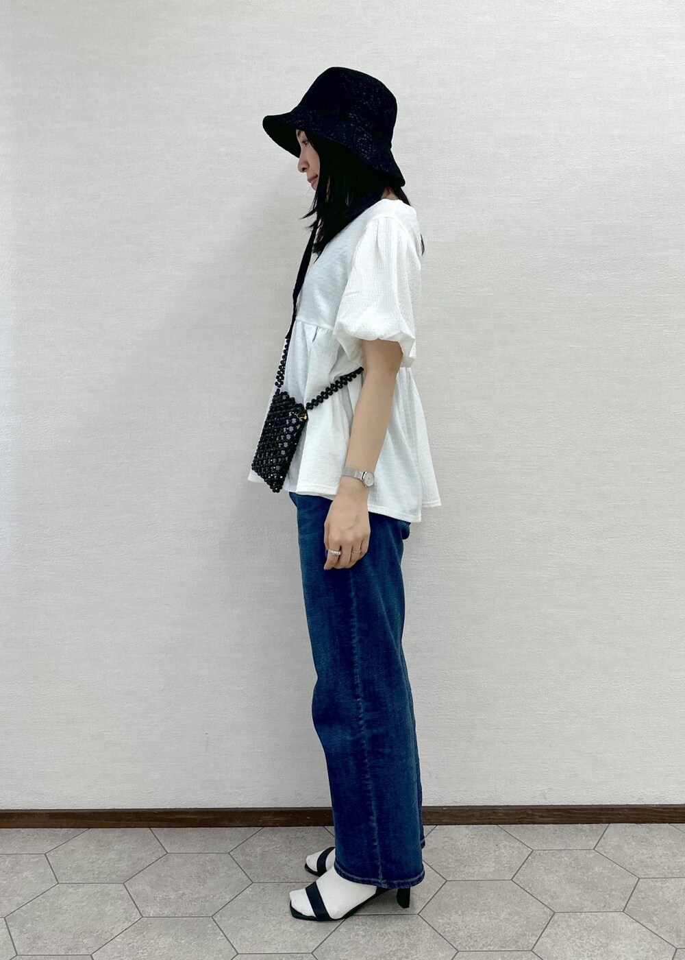 ブラック系のショルダーバッグ、ブルー系のデニムパンツ、ホワイト系のシャツ/ブラウスを着用したレディースの春コーディネートの3枚目の写真