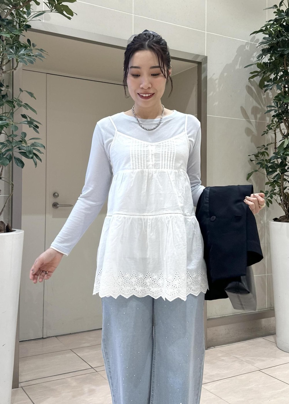 ブルー系のデニムパンツ、ブラック系のショルダーバッグ、ブルー系のテーラードジャケットを着用したレディースの冬コーディネートの10枚目の写真