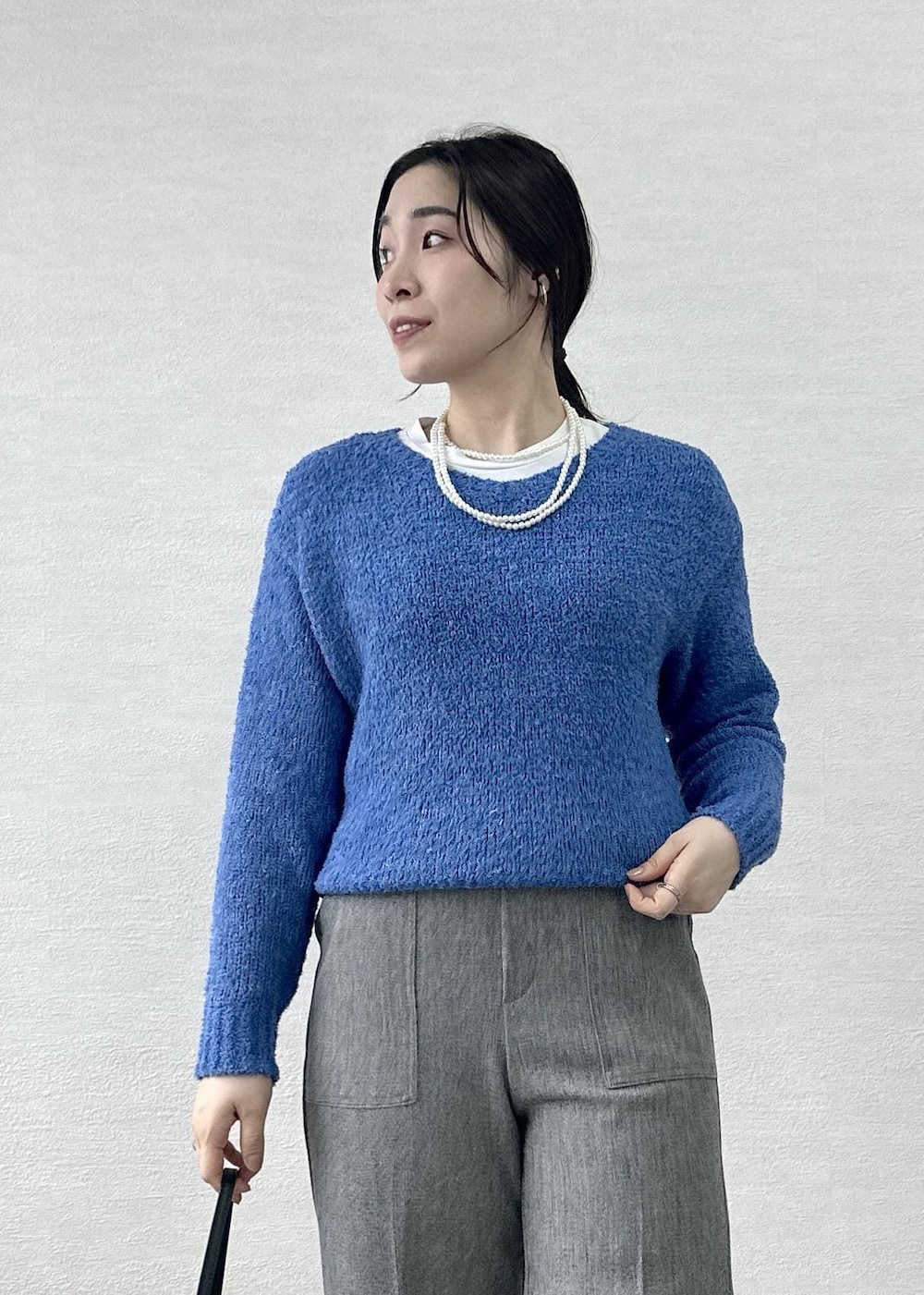 ブラック系のショルダーバッグ、ブルー系のニット/セーター、グレー系のその他パンツを着用したレディースの春コーディネートの8枚目の写真