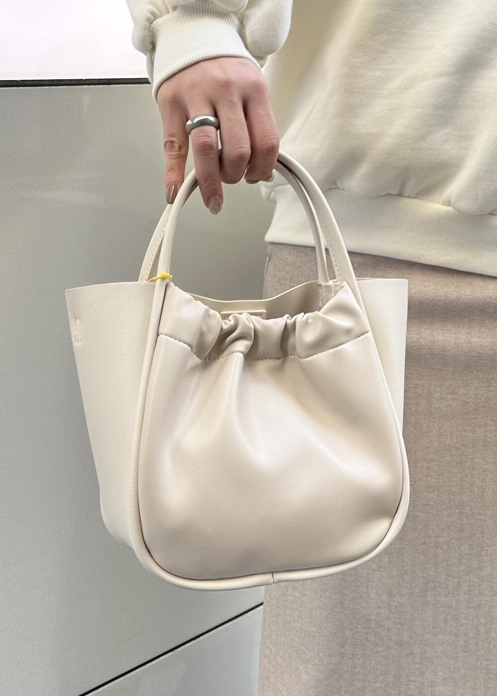 ホワイト系のスウェット、ベージュ系のスカートを着用したレディースの冬コーディネートの3枚目の写真