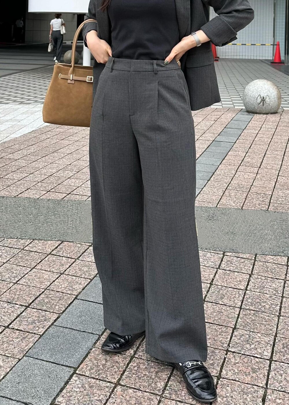 ブラック系のタンクトップ、イエロー系のトートバッグ、ブラック系のテーラードジャケットを着用したレディースの秋コーディネートの4枚目の写真