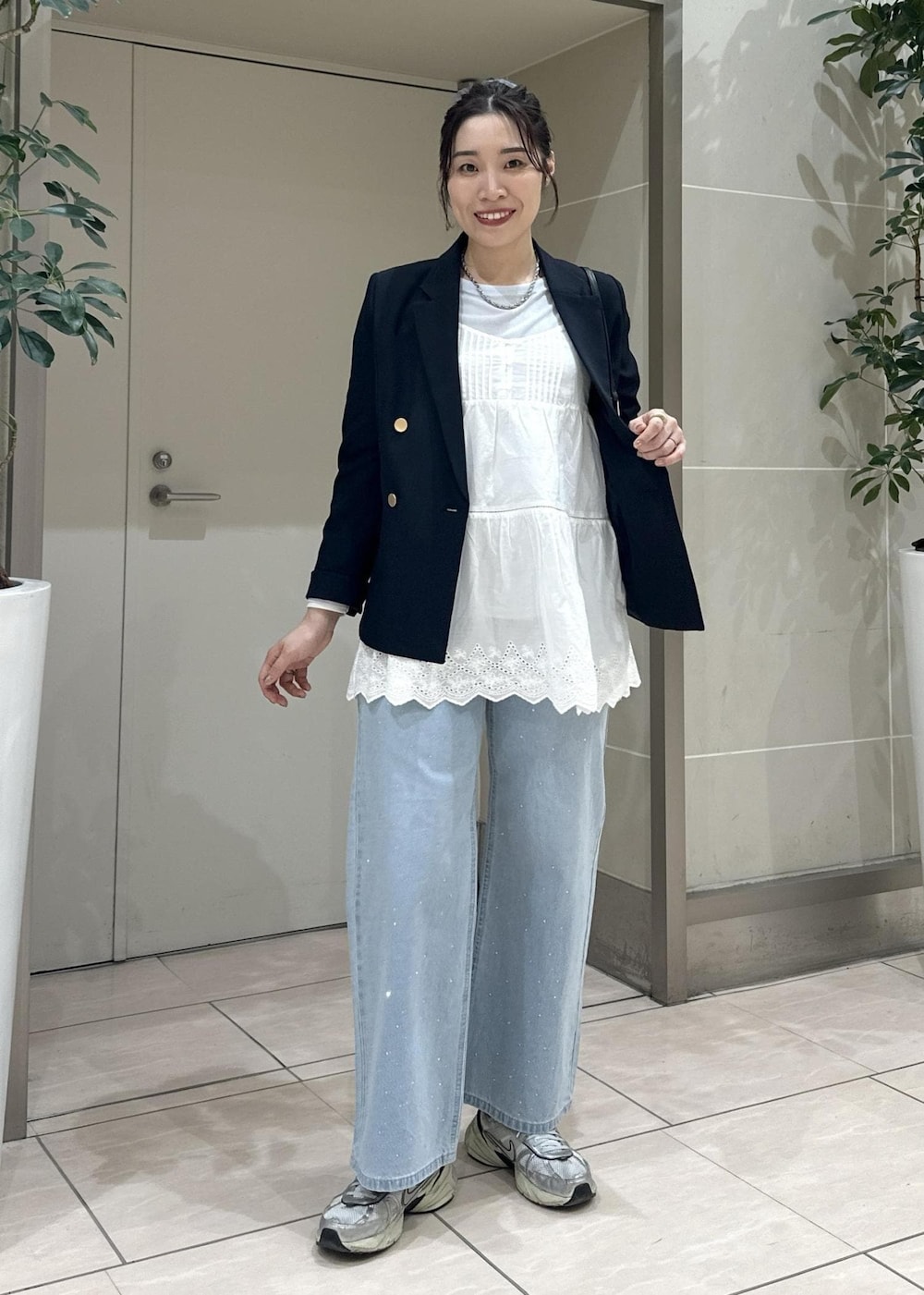 ブルー系のデニムパンツ、ブラック系のショルダーバッグ、ブルー系のテーラードジャケットを着用したレディースの冬コーディネートの6枚目の写真