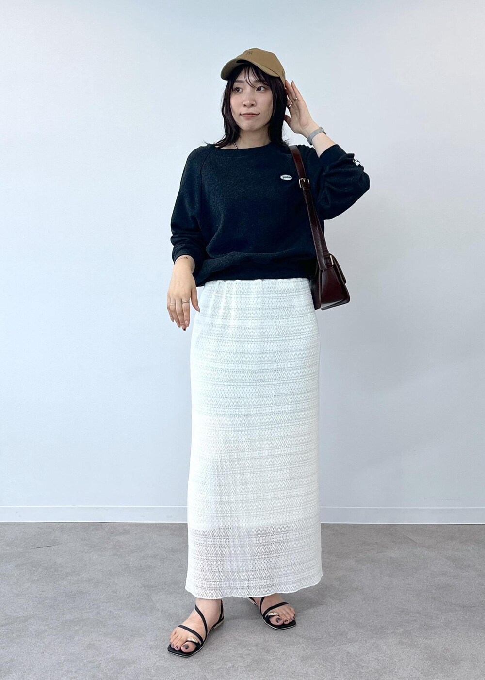 ブラック系のサンダル、ホワイト系のスカート、レッド系のショルダーバッグを着用したレディースの夏コーディネートの4枚目の写真