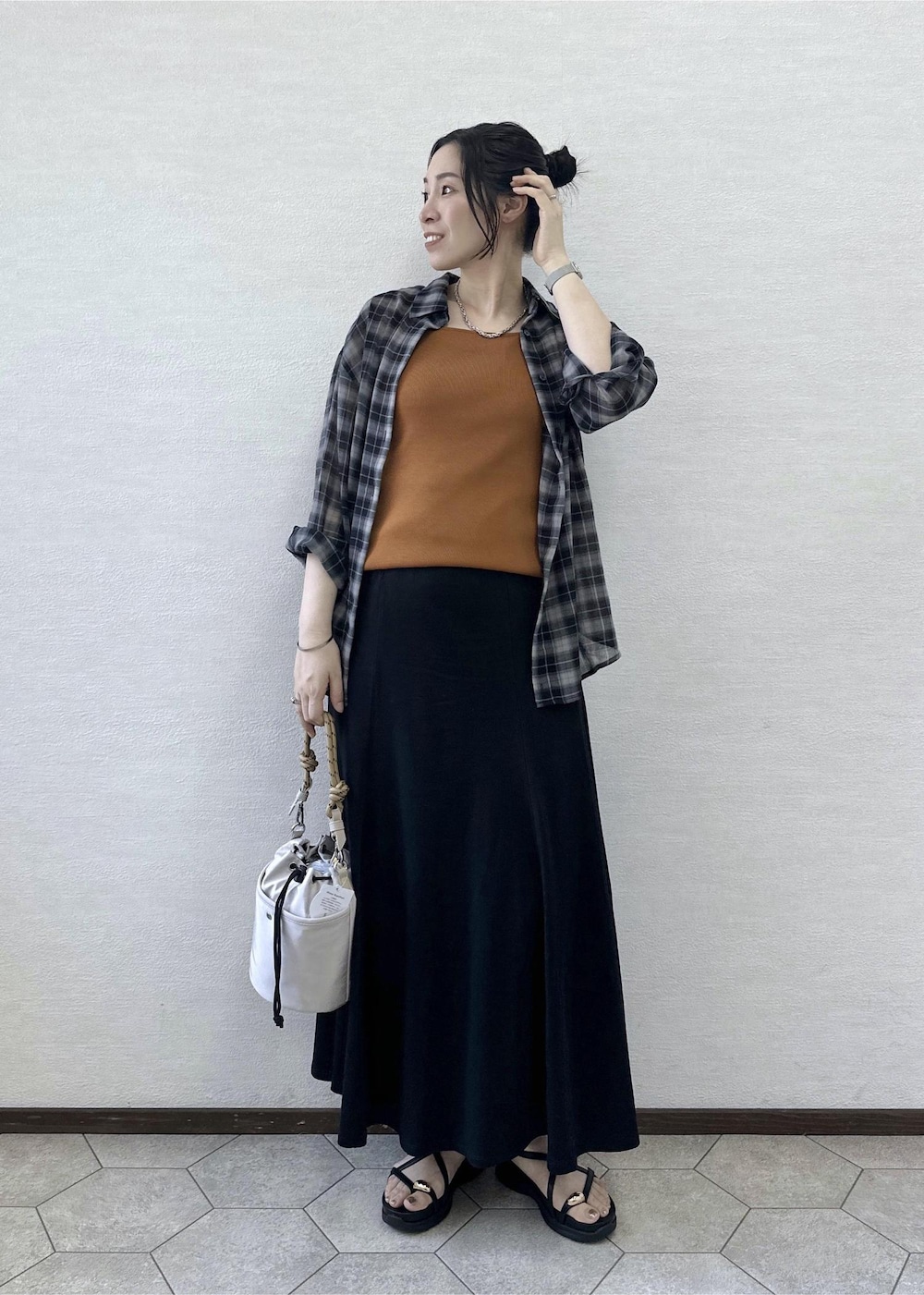 グレー系のショルダーバッグ、ブラック系のサンダル、イエロー系のタンクトップを着用したレディースの夏コーディネートの2枚目の写真