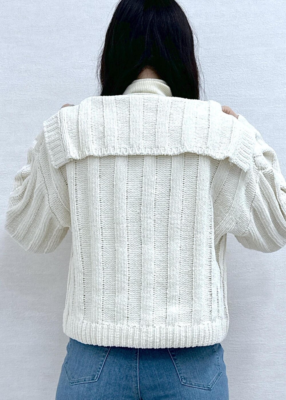 ホワイト系のニット/セーター、ホワイト系のニット/セーター、ブルー系のデニムパンツを着用したレディースの冬コーディネートの7枚目の写真