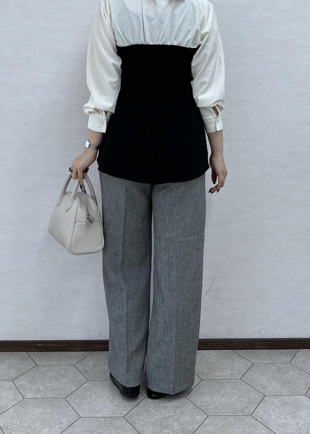 ブラック系のシャツ/ブラウス、グレー系のその他パンツ、ベージュ系のボストンバッグを着用したレディースの秋コーディネートの6枚目の写真