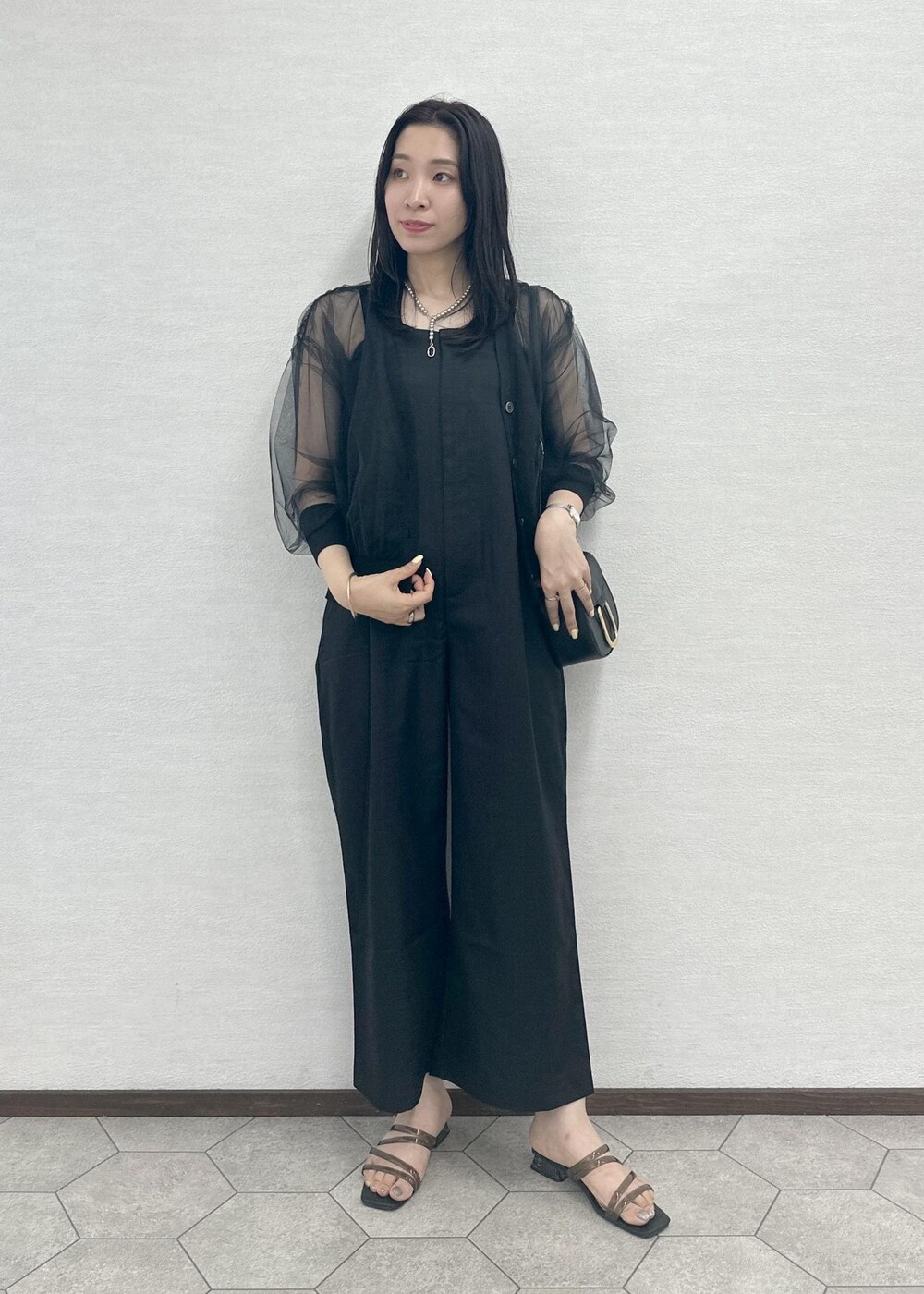 ブラック系のつなぎ/オールインワン、ブラック系のショルダーバッグ、ブラック系のカーディガン/ボレロを着用したレディースの夏コーディネートの4枚目の写真