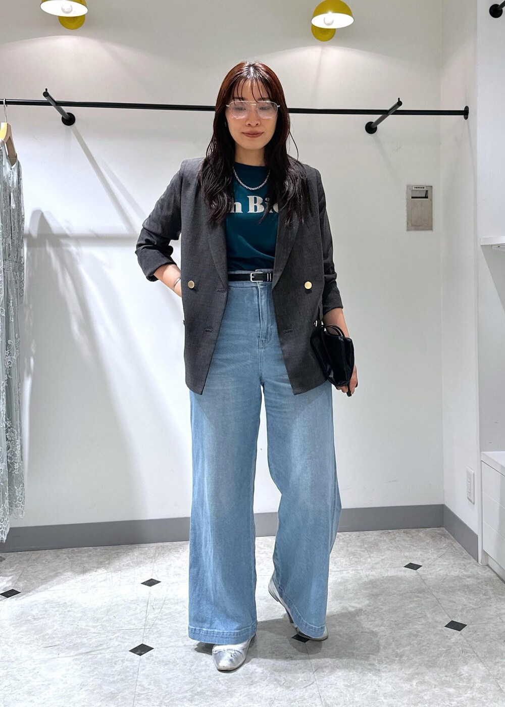 シルバー系のバレエシューズ、ブラック系のトートバッグ、ブルー系のデニムパンツを着用したレディースの夏コーディネートの3枚目の写真