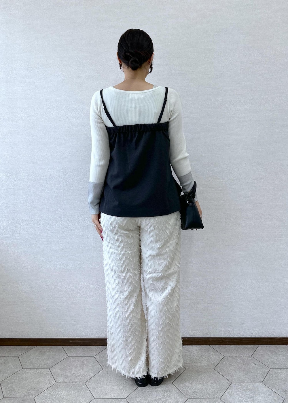ブラック系のショルダーバッグ、ホワイト系のニット/セーター、グレー系のベストを着用したレディースの秋コーディネートの4枚目の写真