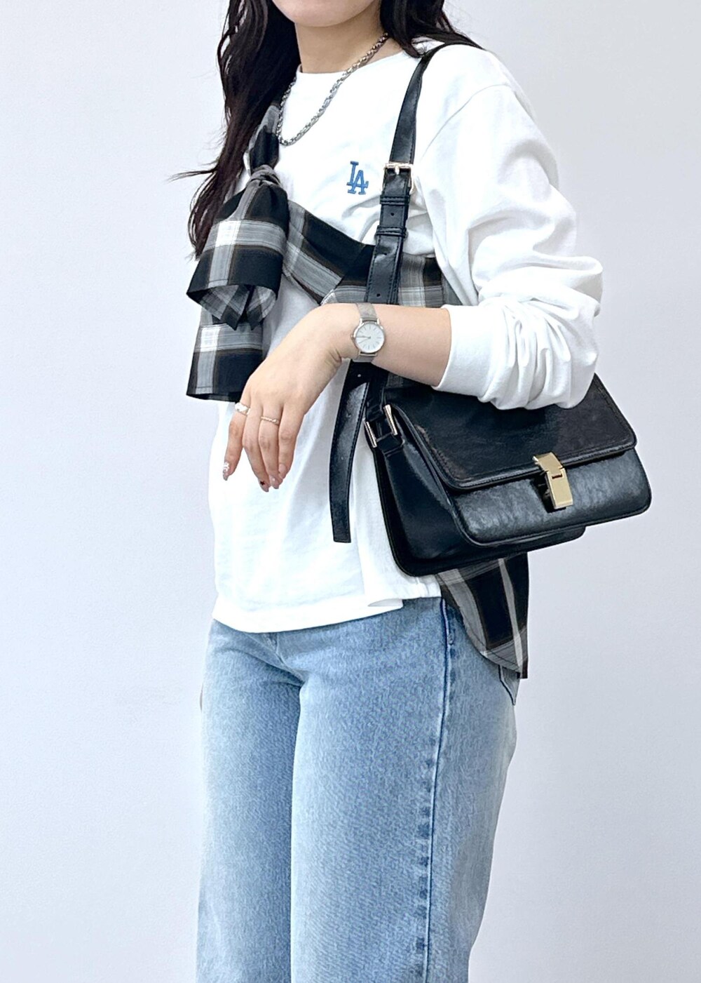 ブルー系のデニムパンツ、シルバー系のバレエシューズ、ブラック系のショルダーバッグを着用したレディースの夏コーディネートの8枚目の写真