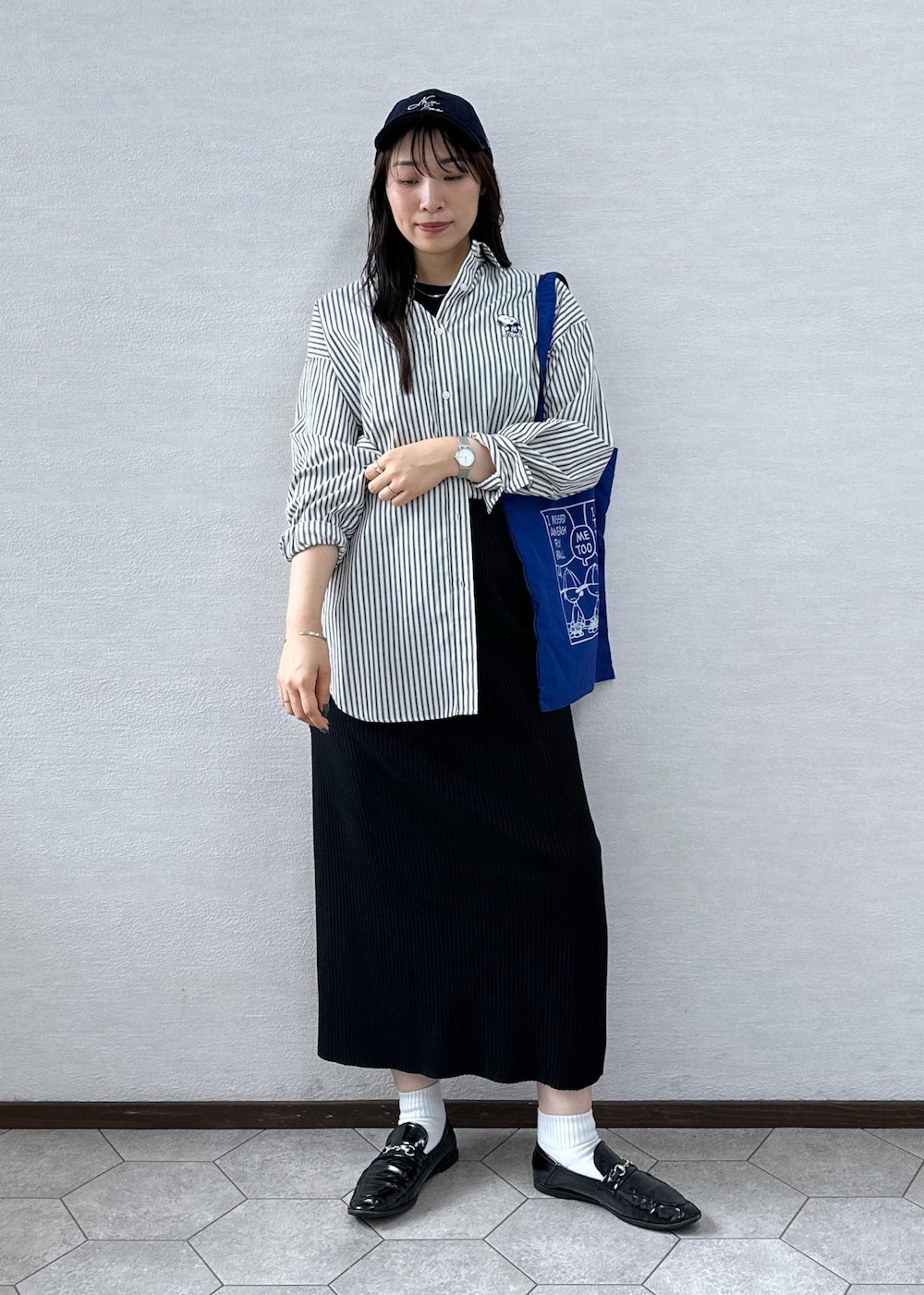 ブラック系のスカート、ホワイト系のシャツ/ブラウス、ブルー系のトートバッグを着用したレディースの秋コーディネートの3枚目の写真