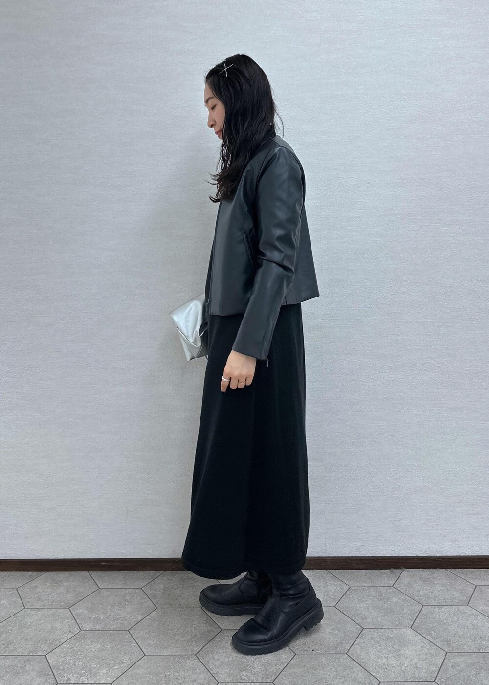 ブラック系のワンピース、ブラック系のノーカラージャケット、シルバー系のトートバッグを着用したレディースの冬コーディネートの3枚目の写真