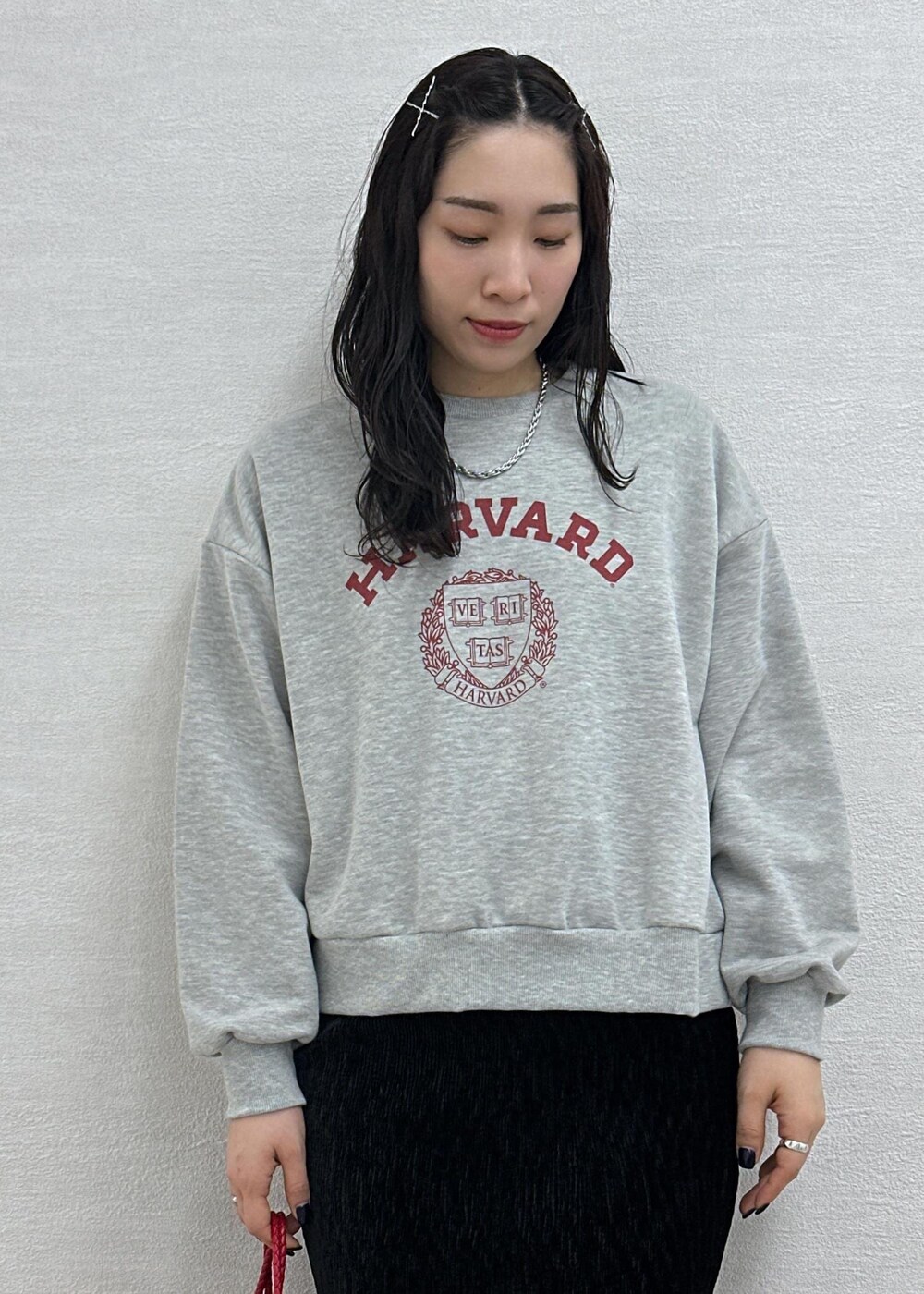 グレー系のスウェット、レッド系のトートバッグ、ブラック系のスカートを着用したレディースの冬コーディネートの6枚目の写真