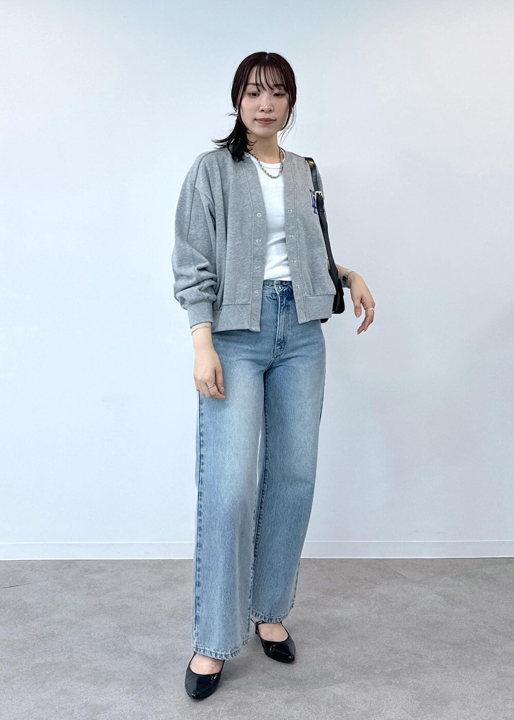 グレー系のデニムパンツ、ホワイト系のタンクトップ、ブラック系のショルダーバッグを着用したレディースの夏コーディネートの2枚目の写真