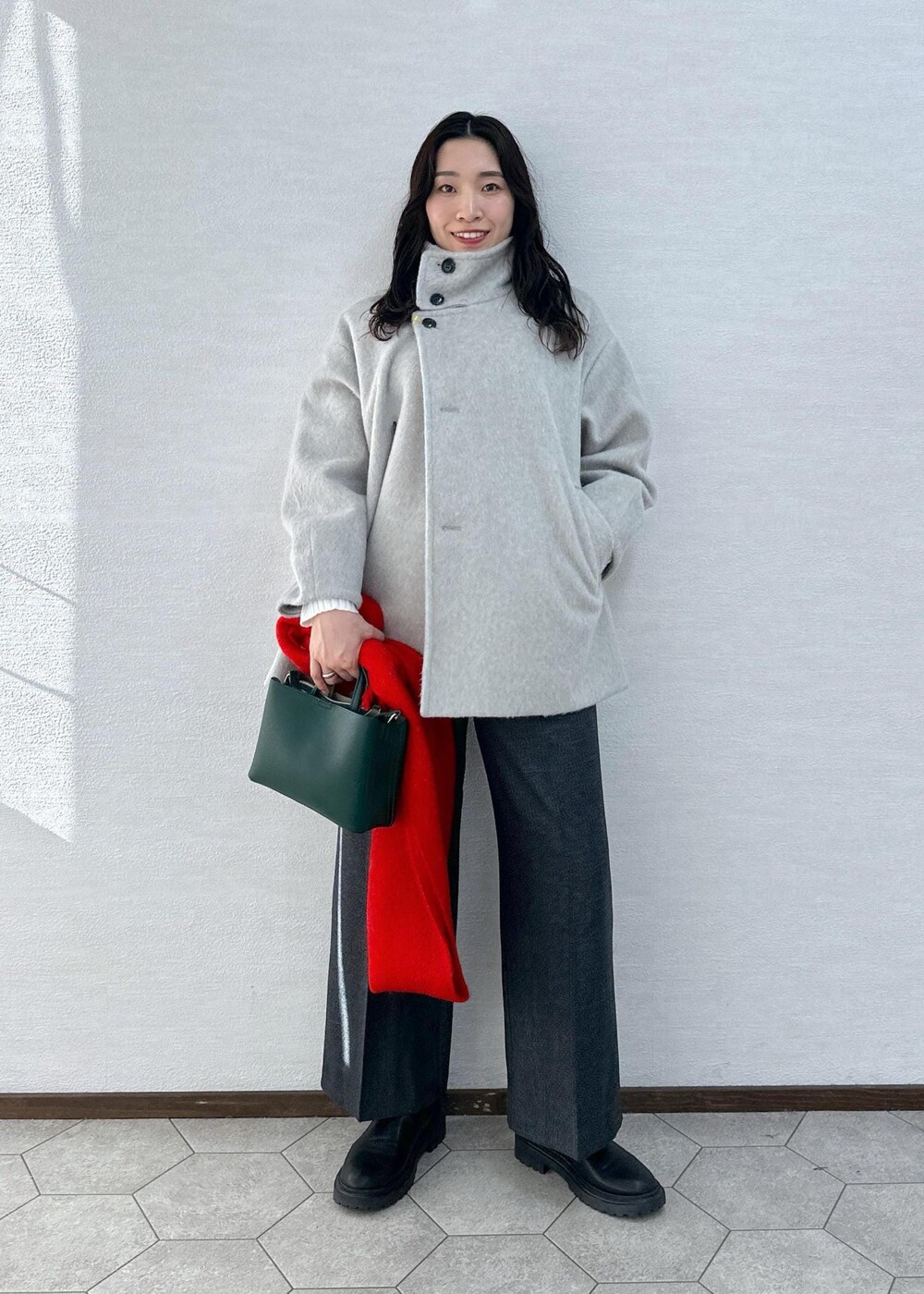 ホワイト系のニット/セーター、グレー系のその他アウター、グレー系のその他パンツを着用したレディースの冬コーディネートの2枚目の写真