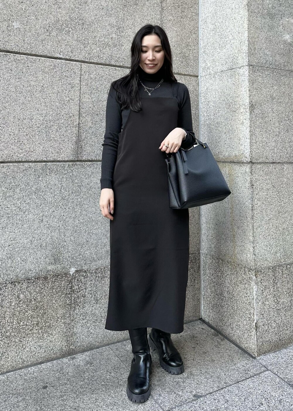 ブラック系のワンピース、グレー系のニット/セーター、ブラック系のその他アウターを着用したレディースの冬コーディネートの3枚目の写真