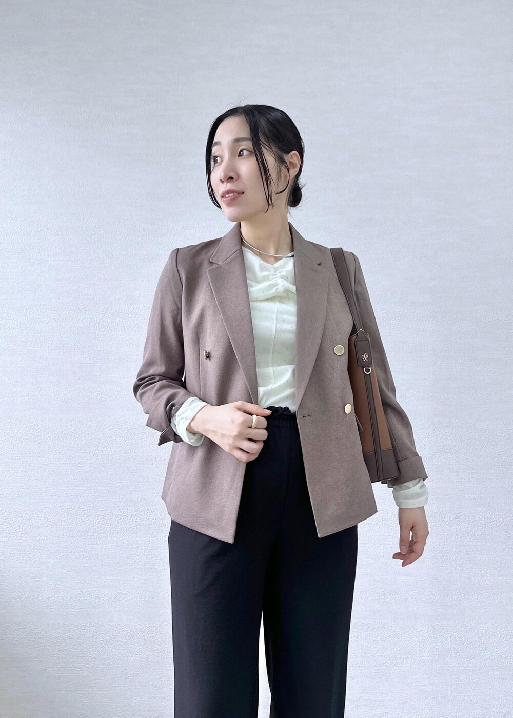 ブラック系のその他パンツ、ホワイト系のTシャツ/カットソー、ベージュ系のテーラードジャケットを着用したレディースの秋コーディネートの6枚目の写真