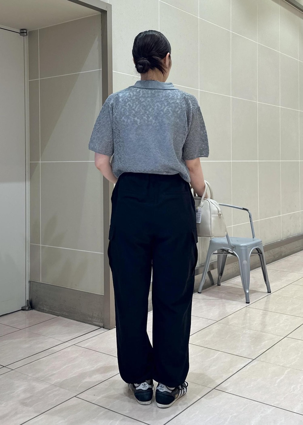 ベージュ系のボストンバッグ、ブラック系のカーゴパンツ、ホワイト系のタンクトップを着用したレディースの夏コーディネートの5枚目の写真