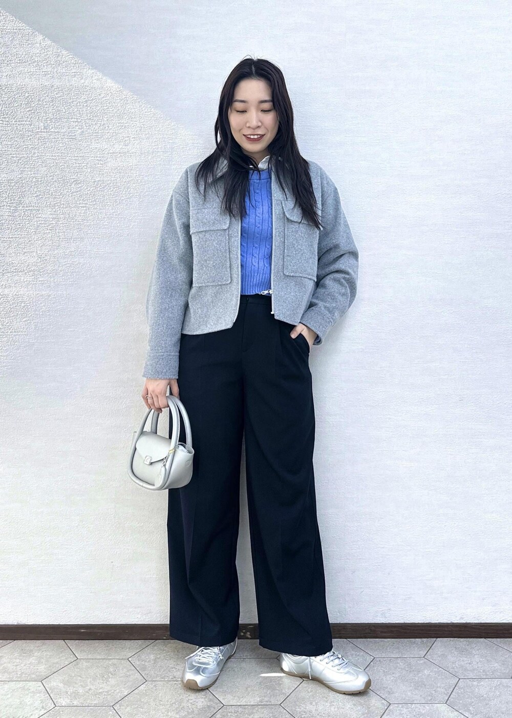 グレー系のブルゾン、ブルー系のその他パンツ、シルバー系のショルダーバッグを着用したレディースの冬コーディネートの2枚目の写真