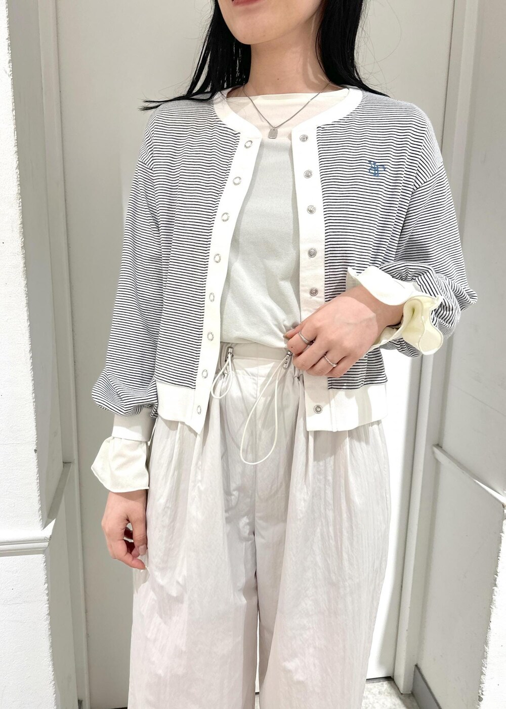 ベージュ系のその他パンツ、ホワイト系のカーディガン/ボレロ、ホワイト系のTシャツ/カットソーを着用したレディースの春コーディネートの4枚目の写真