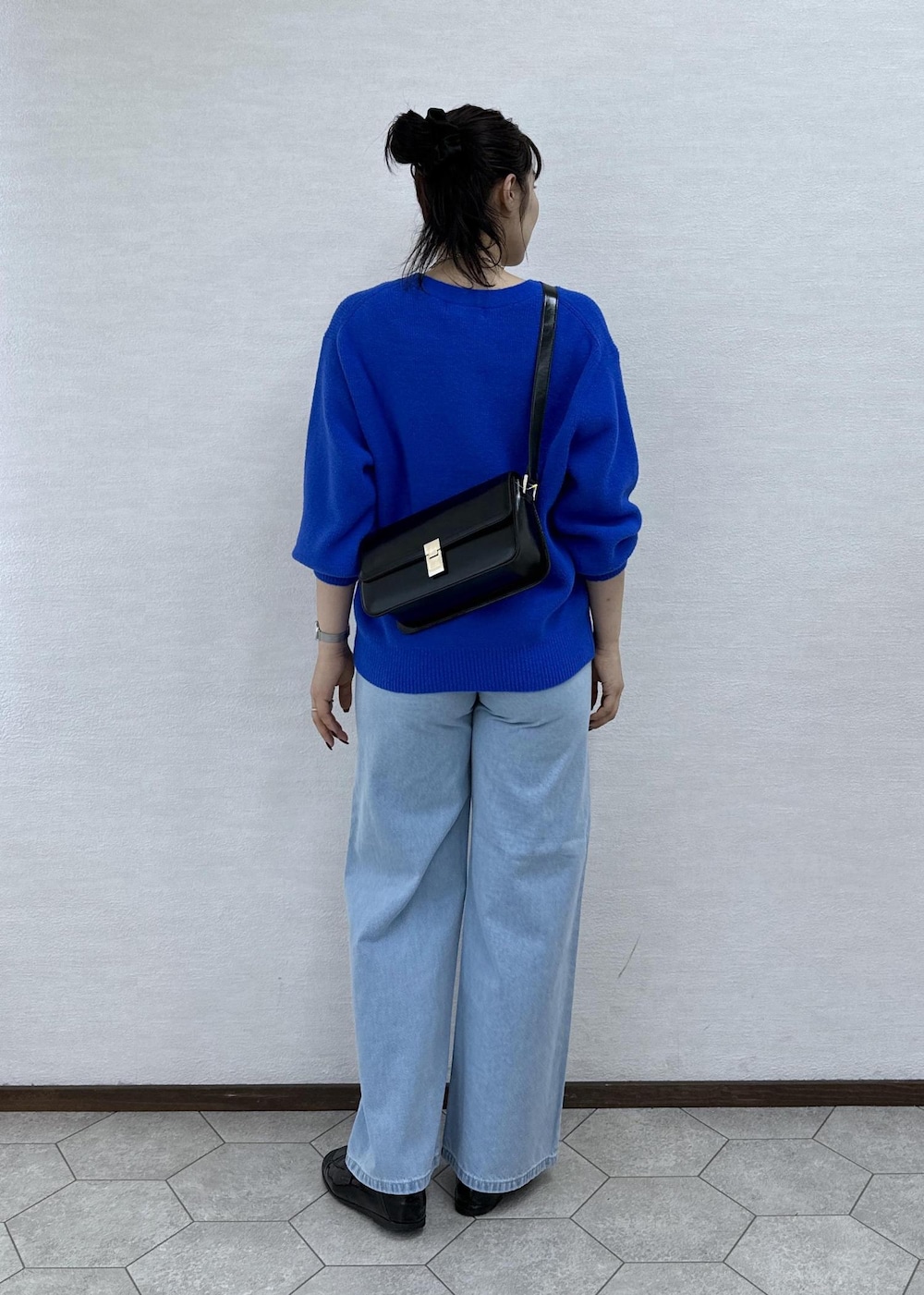 ブルー系のカーディガン/ボレロ、ブラック系のショルダーバッグ、ブルー系のデニムパンツを着用したレディースの秋コーディネートの6枚目の写真