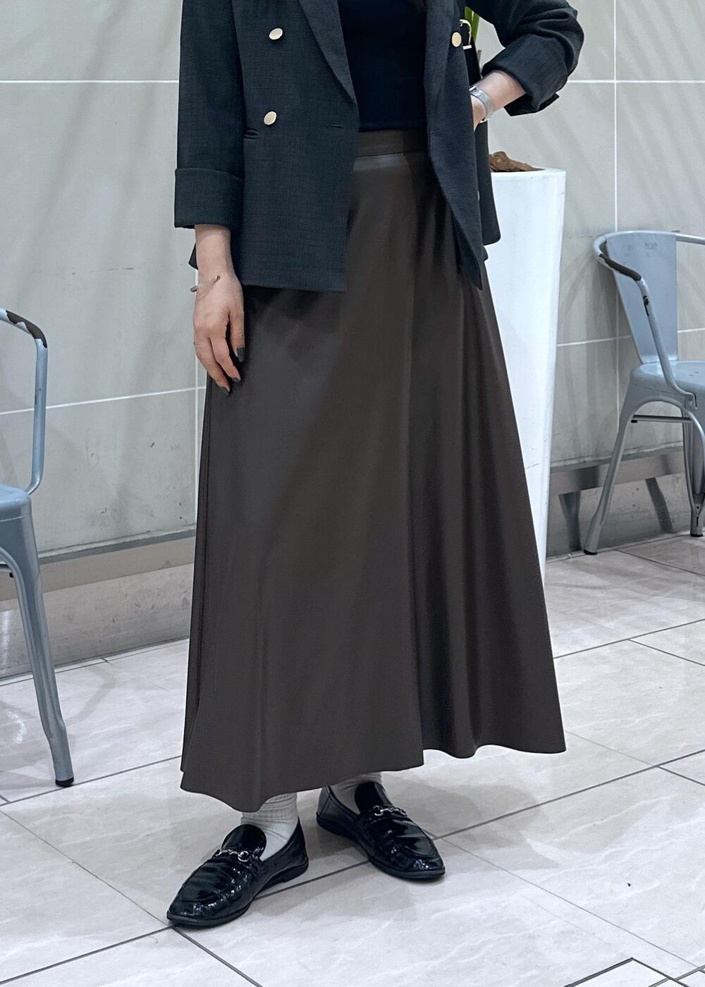 ブラック系のショルダーバッグ、ブラック系のテーラードジャケット、ブラウン系のスカートを着用したレディースの秋コーディネートの8枚目の写真