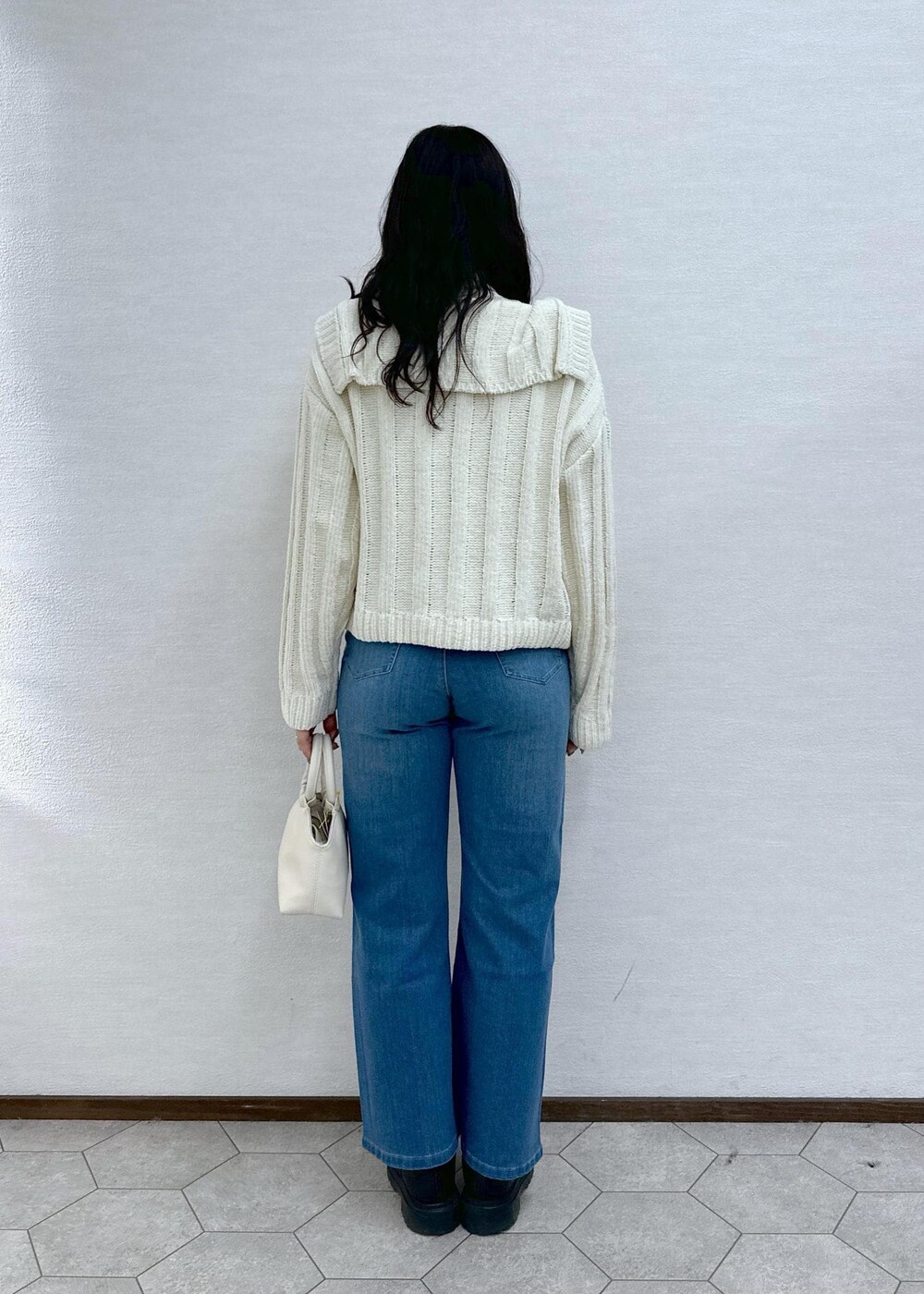 ホワイト系のニット/セーター、ホワイト系のニット/セーター、ブルー系のデニムパンツを着用したレディースの冬コーディネートの4枚目の写真