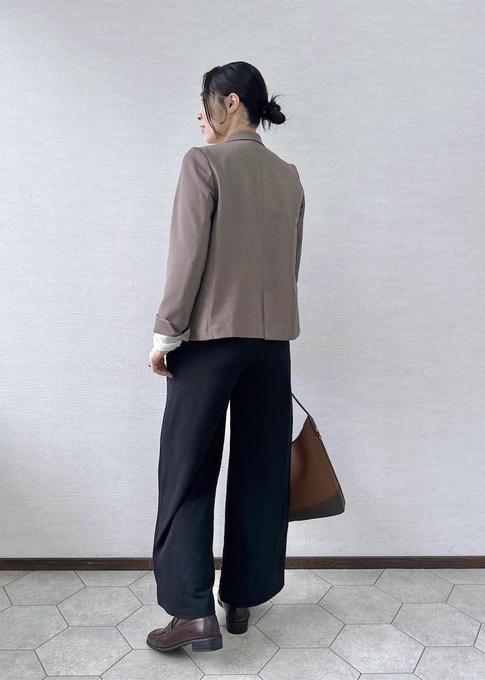 ブラック系のその他パンツ、ホワイト系のTシャツ/カットソー、ベージュ系のテーラードジャケットを着用したレディースの秋コーディネートの3枚目の写真