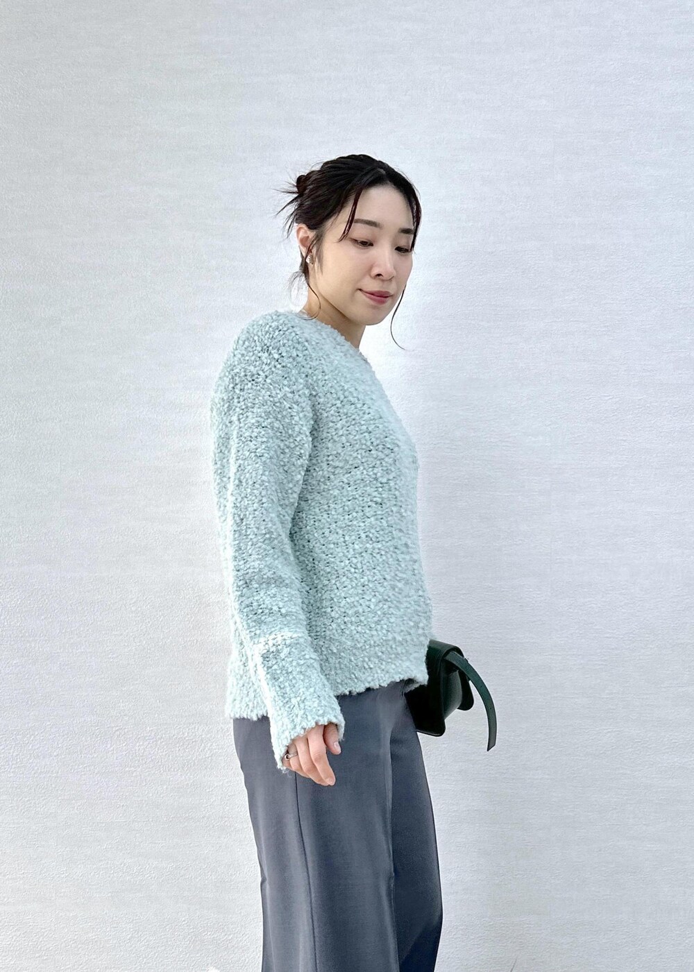 グリーン系のショルダーバッグ、グレー系のその他パンツ、グリーン系のニット/セーターを着用したレディースの冬コーディネートの6枚目の写真