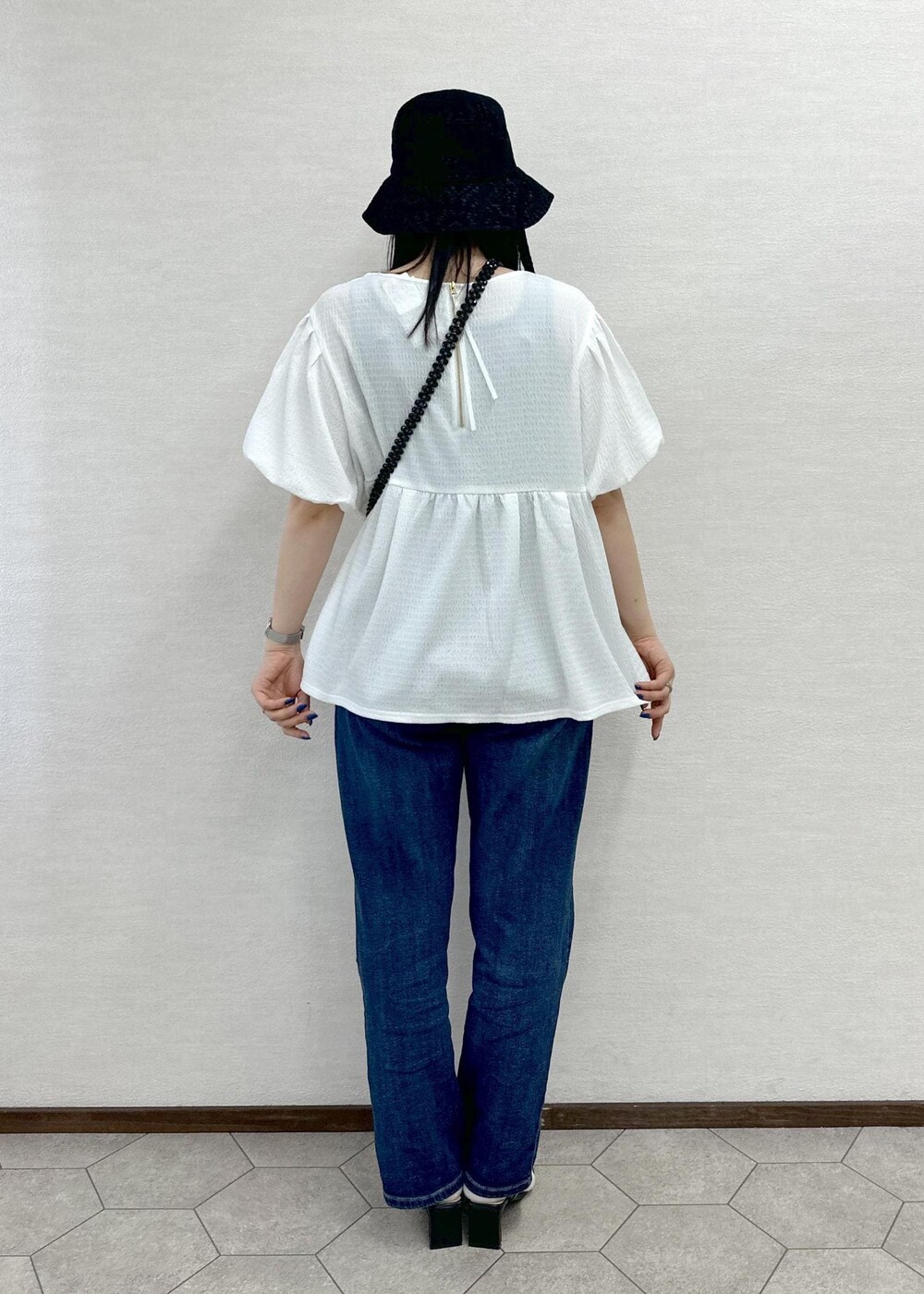 ブラック系のショルダーバッグ、ブルー系のデニムパンツ、ホワイト系のシャツ/ブラウスを着用したレディースの春コーディネートの4枚目の写真