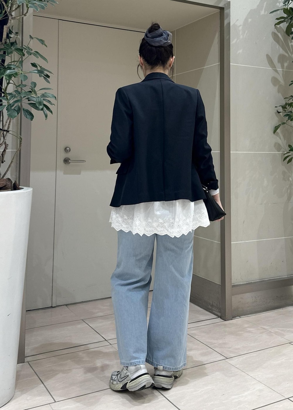 ブルー系のデニムパンツ、ブラック系のショルダーバッグ、ブルー系のテーラードジャケットを着用したレディースの冬コーディネートの4枚目の写真