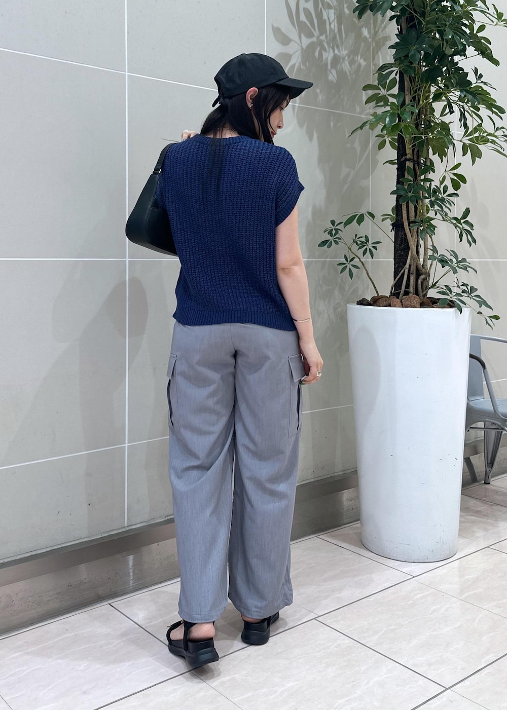 ブルー系のベスト、グレー系のカーゴパンツ、ブラック系のサンダルを着用したレディースの夏コーディネートの5枚目の写真