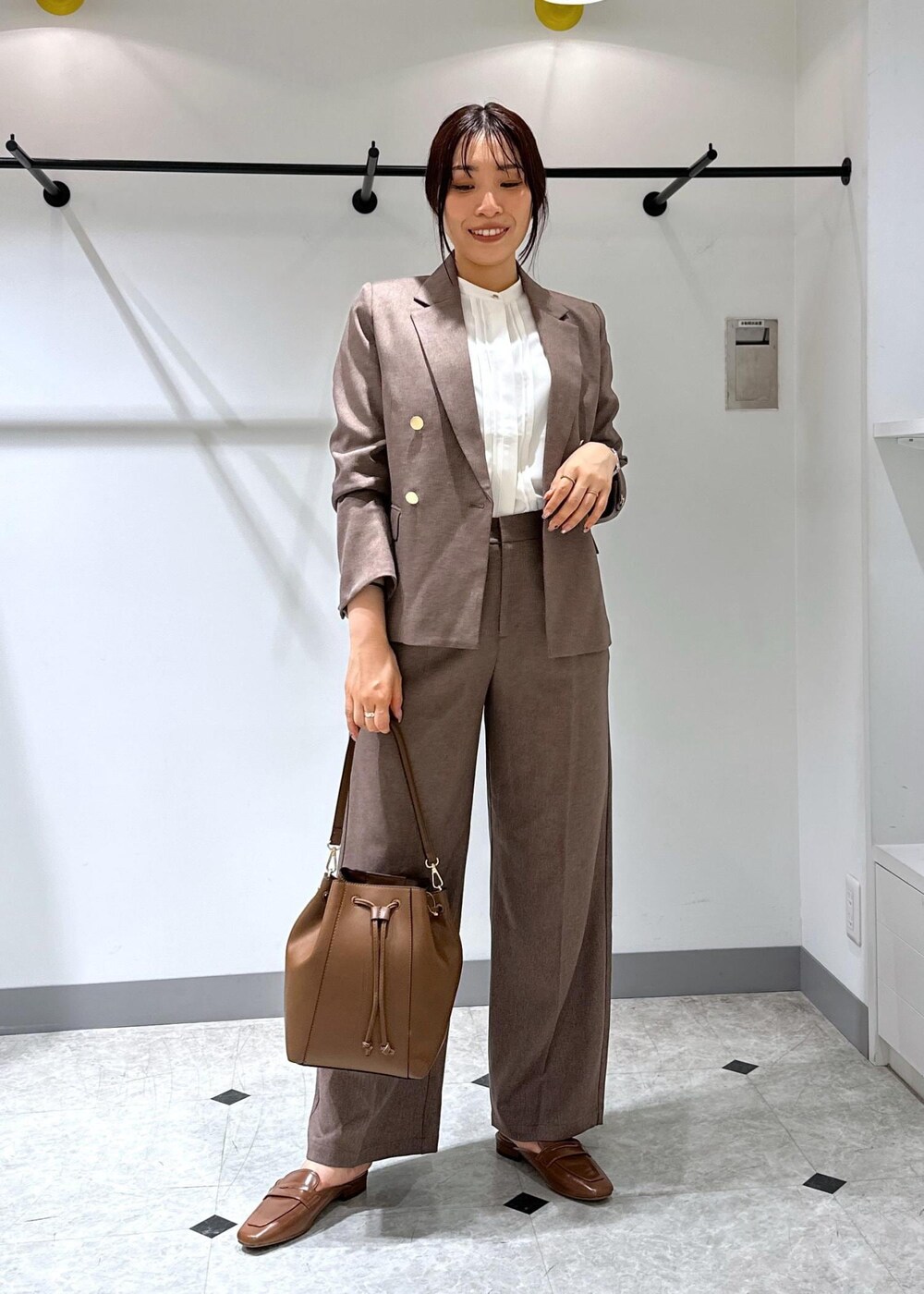 イエロー系のローファー、ブラウン系のショルダーバッグ、ホワイト系のシャツ/ブラウスを着用したレディースの夏コーディネートの2枚目の写真