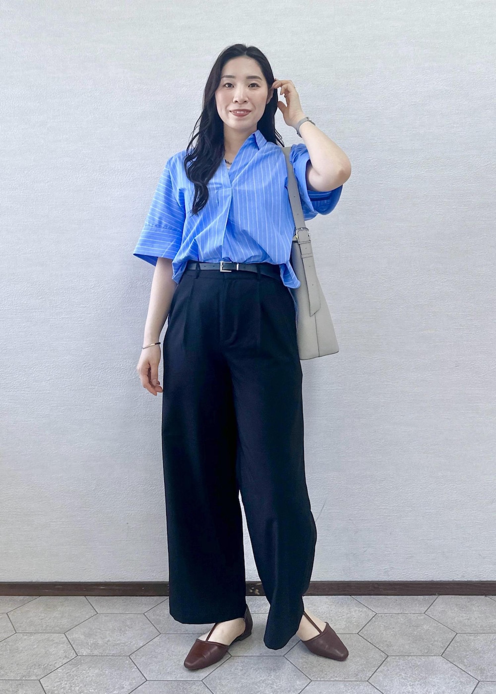 ブラウン系のパンプス、グレー系のショルダーバッグ、ブラック系のその他パンツを着用したレディースの春コーディネートの3枚目の写真