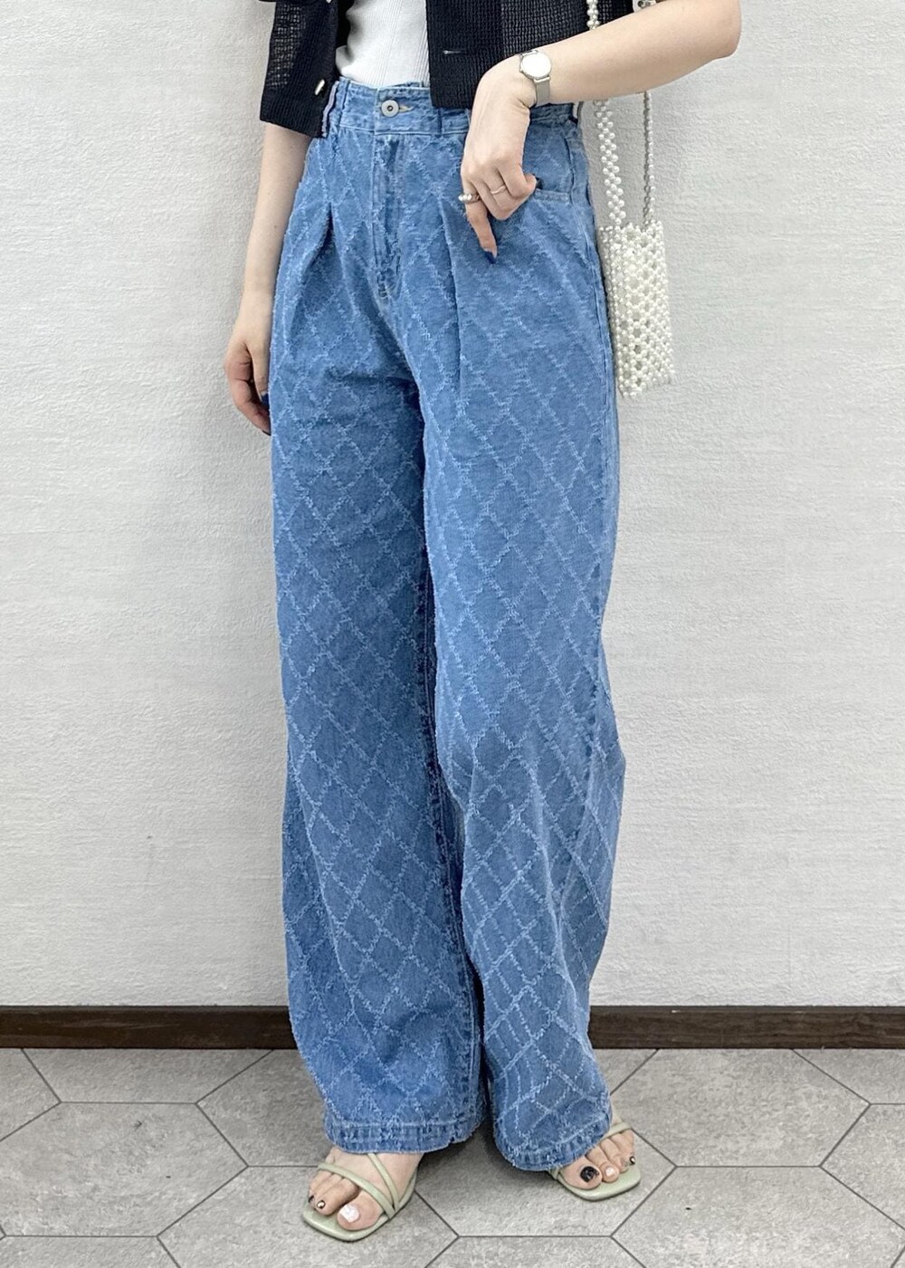 ホワイト系のショルダーバッグ、グレー系のノーカラージャケット、ブルー系のデニムパンツを着用したレディースの夏コーディネートの5枚目の写真
