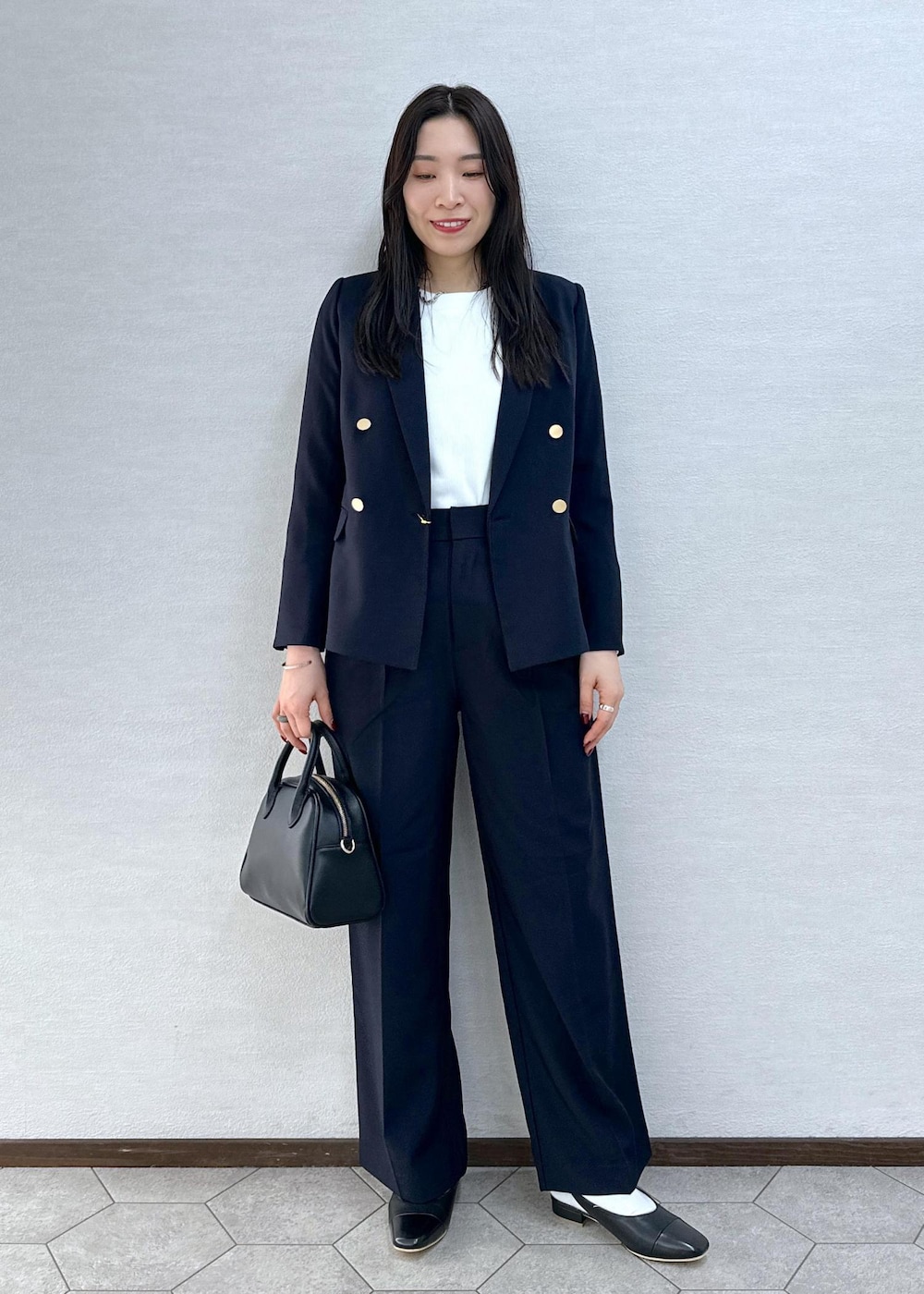 ブラック系のパンプス、ホワイト系のTシャツ/カットソー、ブルー系のその他パンツを着用したレディースの冬コーディネートの2枚目の写真