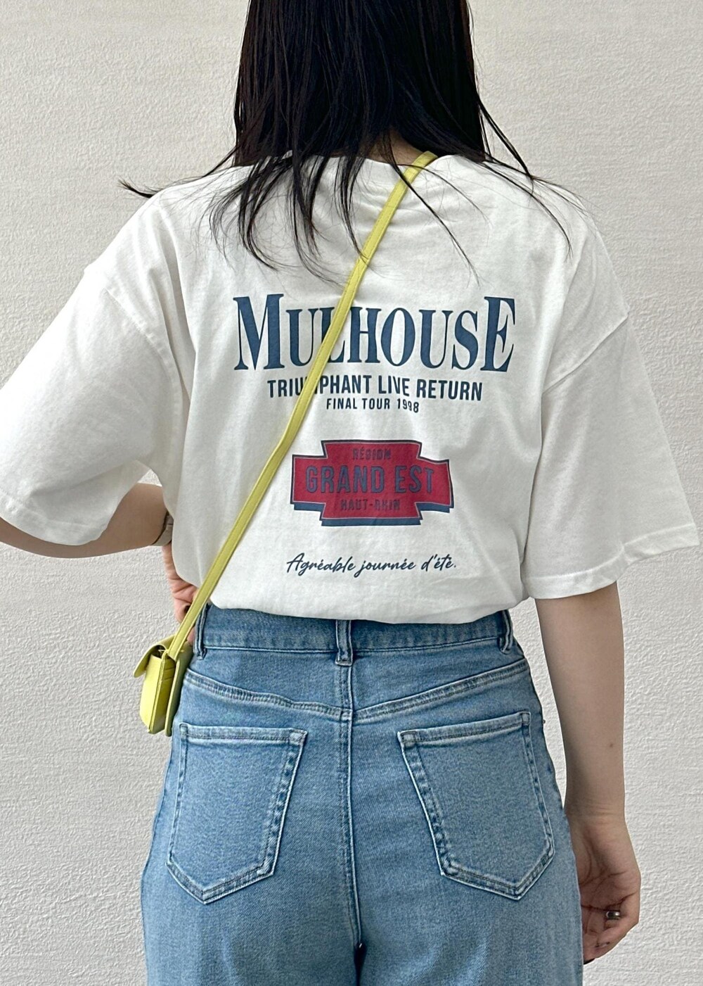 イエロー系のショルダーバッグ、ブルー系のデニムパンツ、ホワイト系のTシャツ/カットソーを着用したレディースの夏コーディネートの8枚目の写真