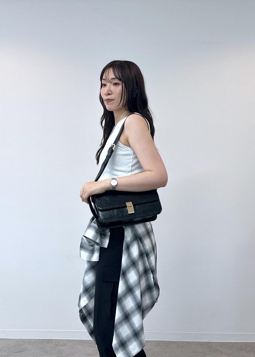 ブラック系のカーゴパンツ、ホワイト系のタンクトップ、ブラック系のショルダーバッグを着用したレディースの夏コーディネートの8枚目の写真