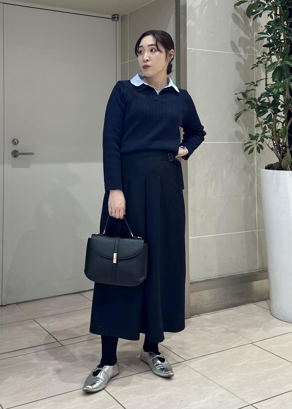 ブルー系のスカート、ブルー系のニット/セーター、ブラック系のショルダーバッグを着用したレディースの冬コーディネートの2枚目の写真