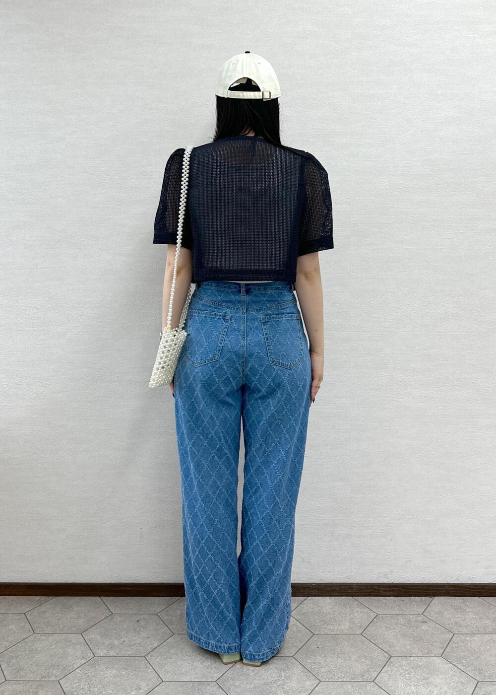 ホワイト系のショルダーバッグ、グレー系のノーカラージャケット、ブルー系のデニムパンツを着用したレディースの夏コーディネートの4枚目の写真