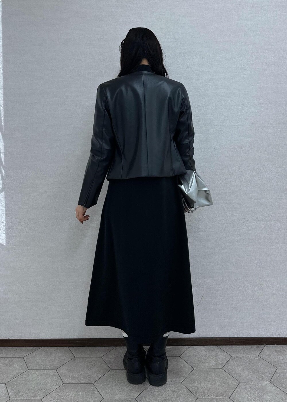 ブラック系のワンピース、ブラック系のノーカラージャケット、シルバー系のトートバッグを着用したレディースの冬コーディネートの4枚目の写真