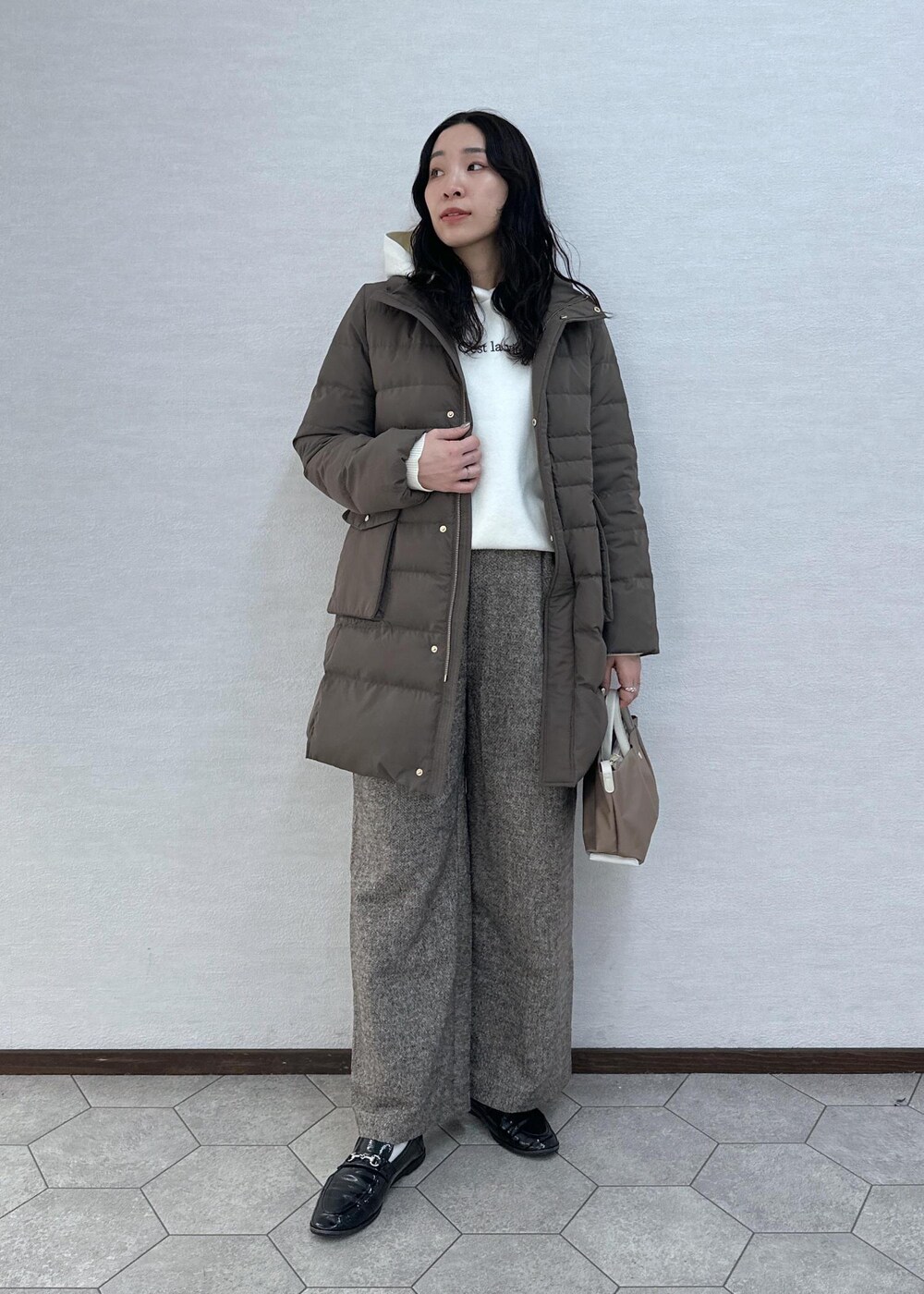 ブラウン系のダウンジャケット/コート、ブラウン系のその他パンツ、ブラウン系のショルダーバッグを着用したレディースの冬コーディネートの3枚目の写真