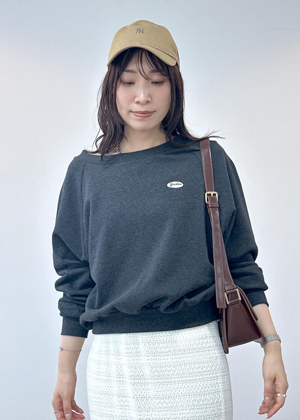 ブラック系のサンダル、ホワイト系のスカート、レッド系のショルダーバッグを着用したレディースの夏コーディネートの7枚目の写真