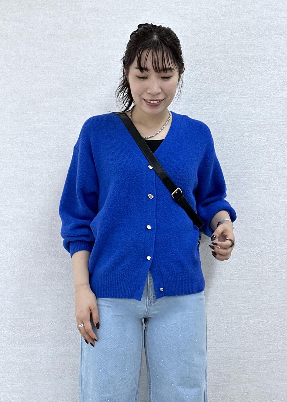 ブルー系のカーディガン/ボレロ、ブラック系のショルダーバッグ、ブルー系のデニムパンツを着用したレディースの秋コーディネートの7枚目の写真