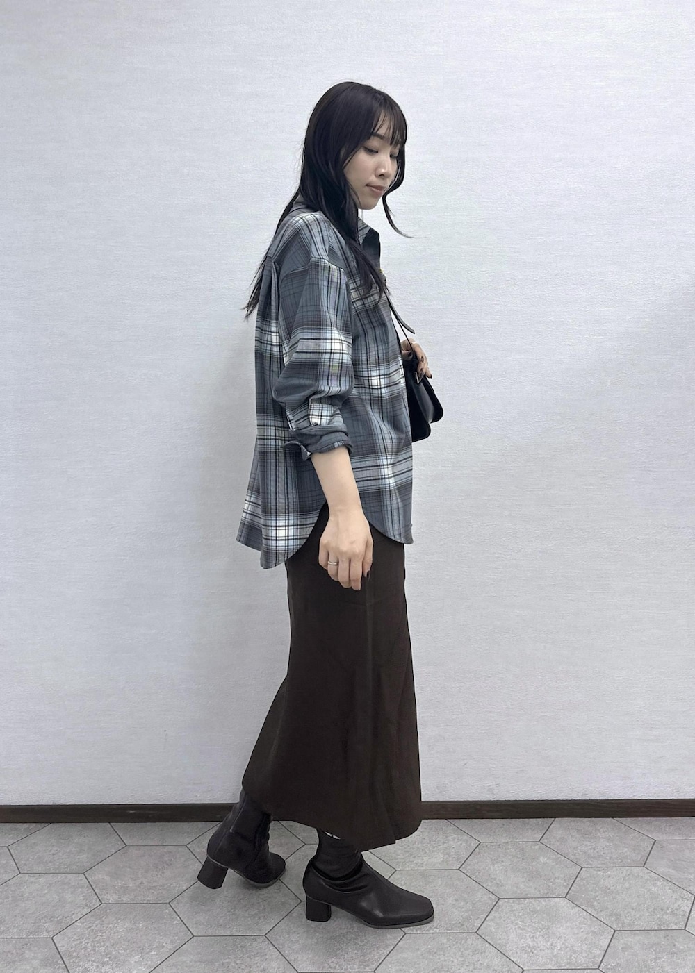 ブラウン系のスカート、ブラック系のショルダーバッグ、グレー系のシャツ/ブラウスを着用したレディースの秋コーディネートの3枚目の写真