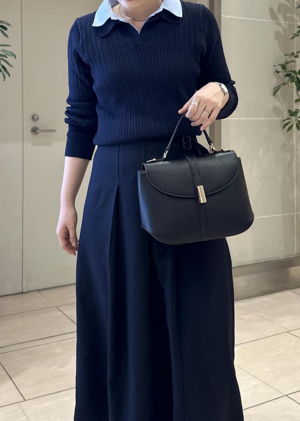 ブルー系のスカート、ブルー系のニット/セーター、ブラック系のショルダーバッグを着用したレディースの冬コーディネートの6枚目の写真