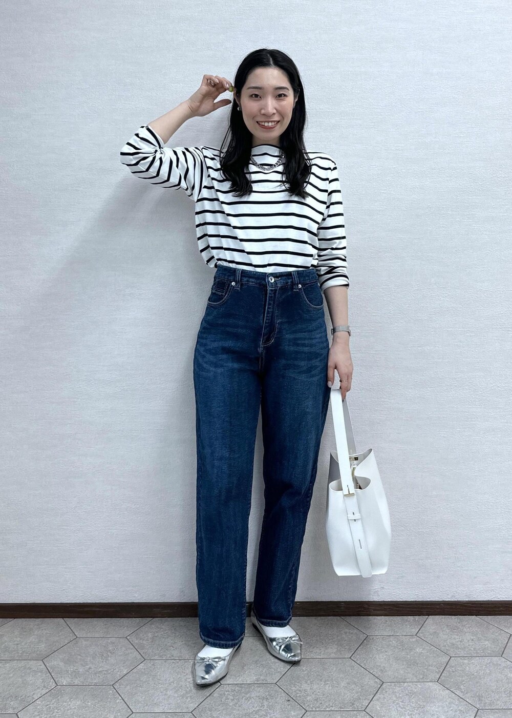 ホワイト系のTシャツ/カットソー、ブルー系のデニムパンツ、ホワイト系のショルダーバッグを着用したレディースの春コーディネートの2枚目の写真