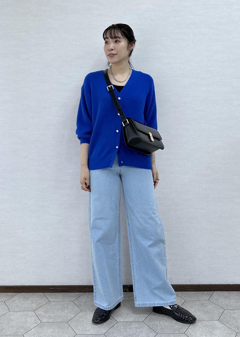 ブルー系のカーディガン/ボレロ、ブラック系のショルダーバッグ、ブルー系のデニムパンツを着用したレディースの秋コーディネートの2枚目の写真