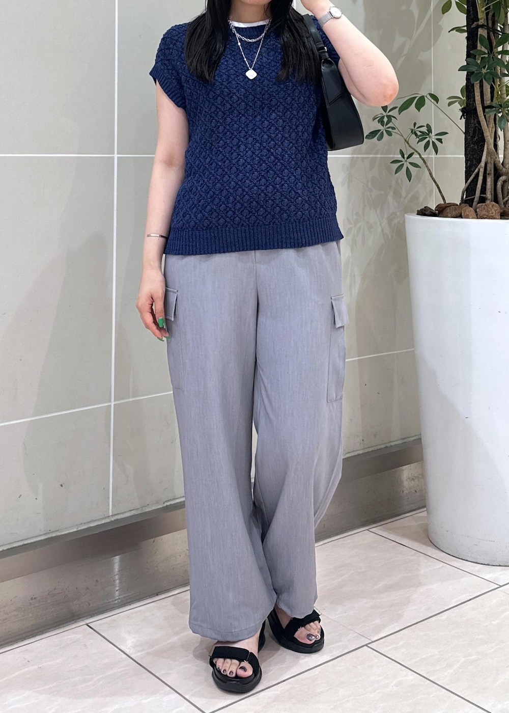 ブルー系のベスト、グレー系のカーゴパンツ、ブラック系のサンダルを着用したレディースの夏コーディネートの7枚目の写真