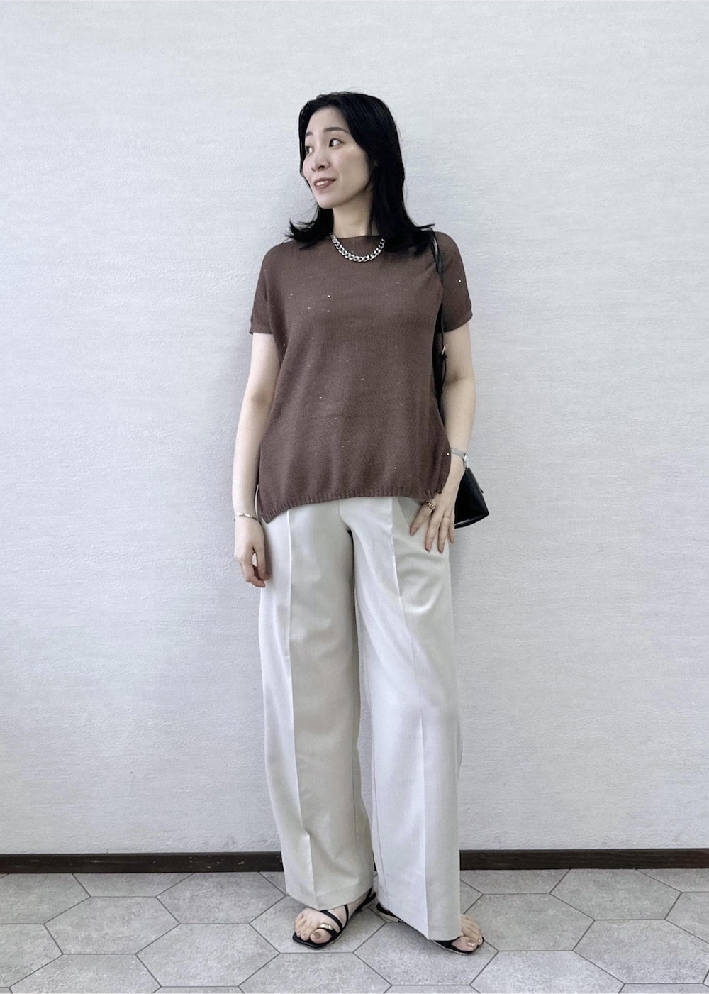 ベージュ系のその他パンツ、ブラック系のショルダーバッグ、イエロー系のニット/セーターを着用したレディースの夏コーディネートの2枚目の写真